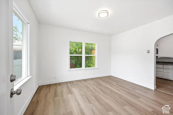 Wood-finish flooring, white walls, and a contemporary flush-mount ceiling light