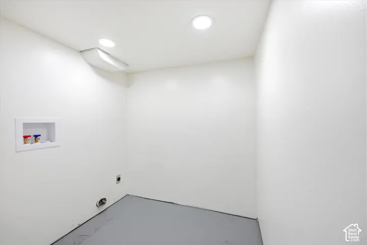 White walls with recessed lighting and a laundry hookup station