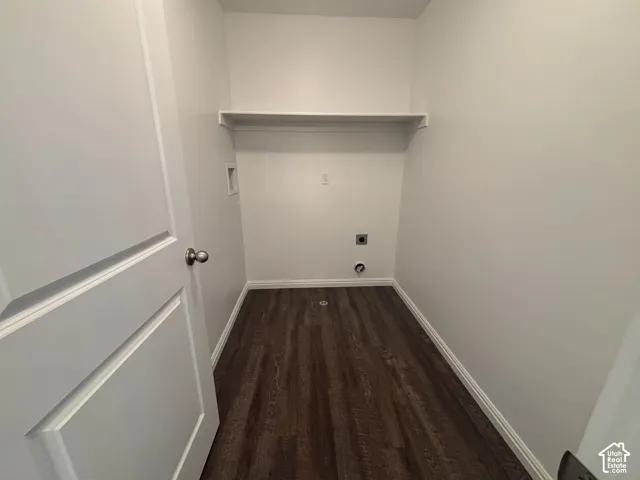 Dedicated utility space featuring a built-in shelf, appliance hookups, and wood-finish flooring
