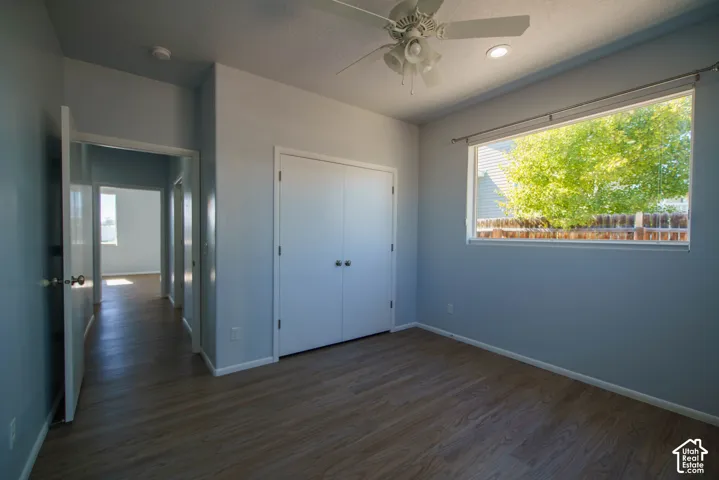 Wood-finish flooring, ceiling fan, recessed lighting, and a large window
