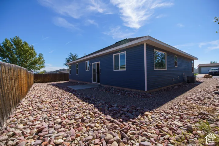 Modern single-story residence with dark exterior siding and white trim, featuring multiple windows and a covered entry