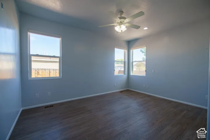 Wood-finish flooring, multiple windows, recessed lighting, and a ceiling fan with light fixture