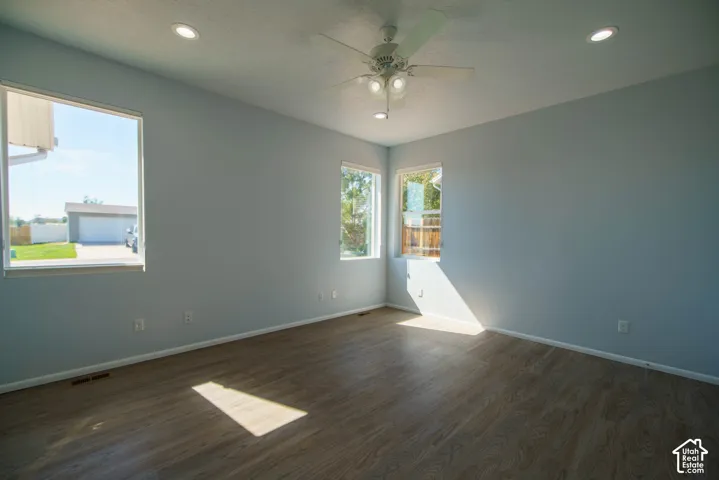 Wood-finish flooring, recessed ceiling lighting, ceiling fan with integrated lighting, and multiple windows