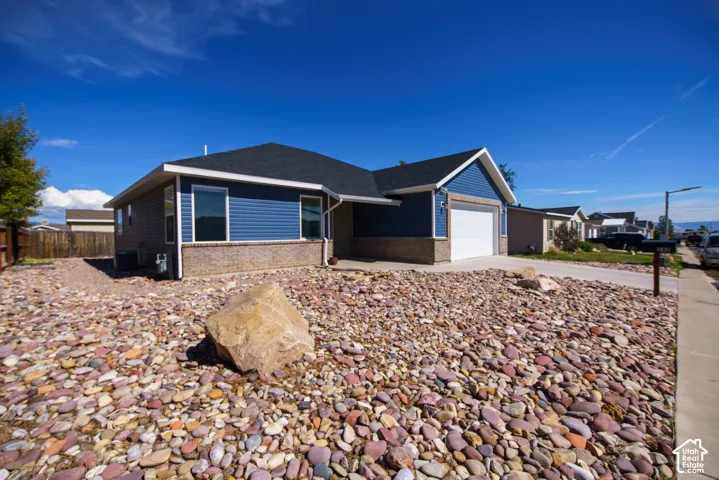 Single-story residence featuring blue siding with a stone accent facade