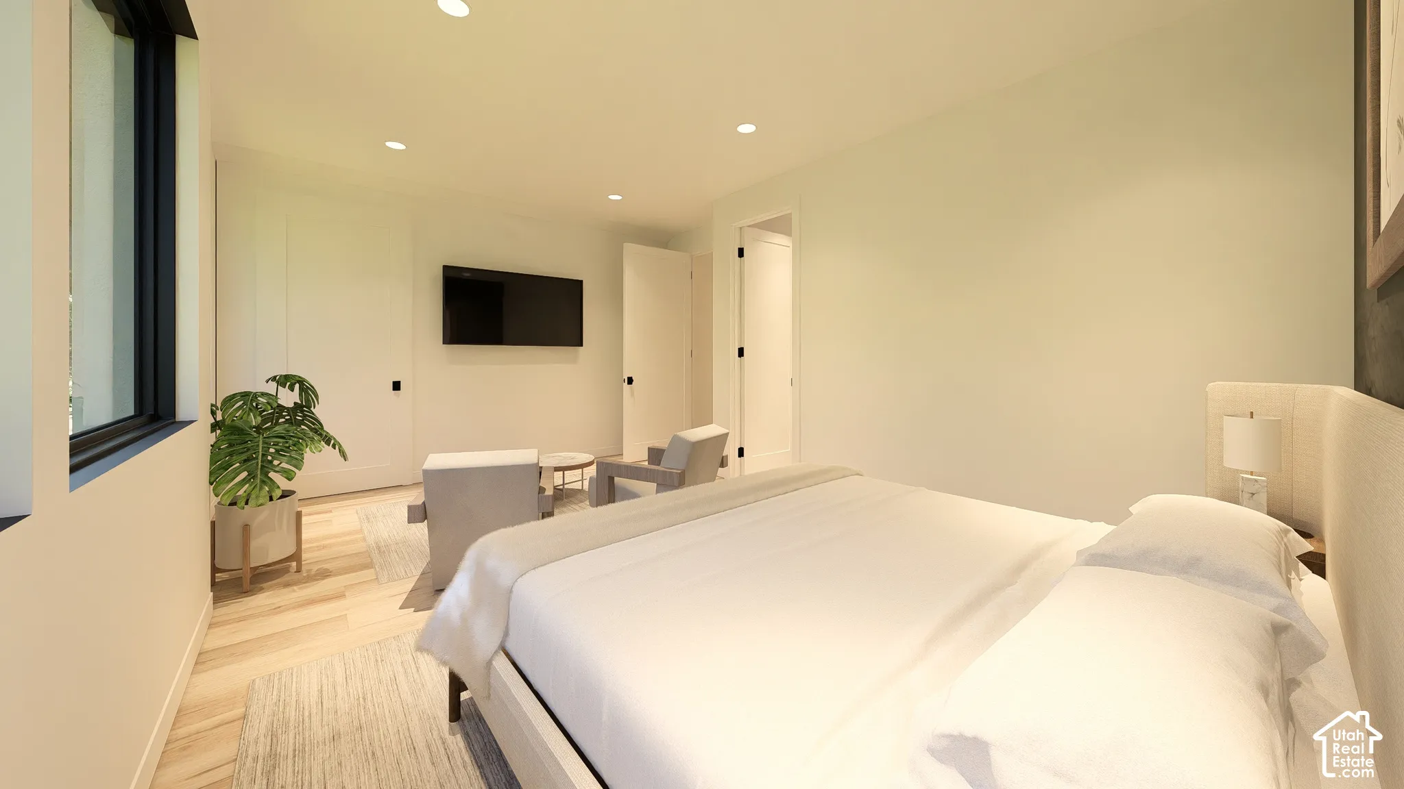 Light wood-finish flooring, recessed lighting, and a mounted flat-screen display