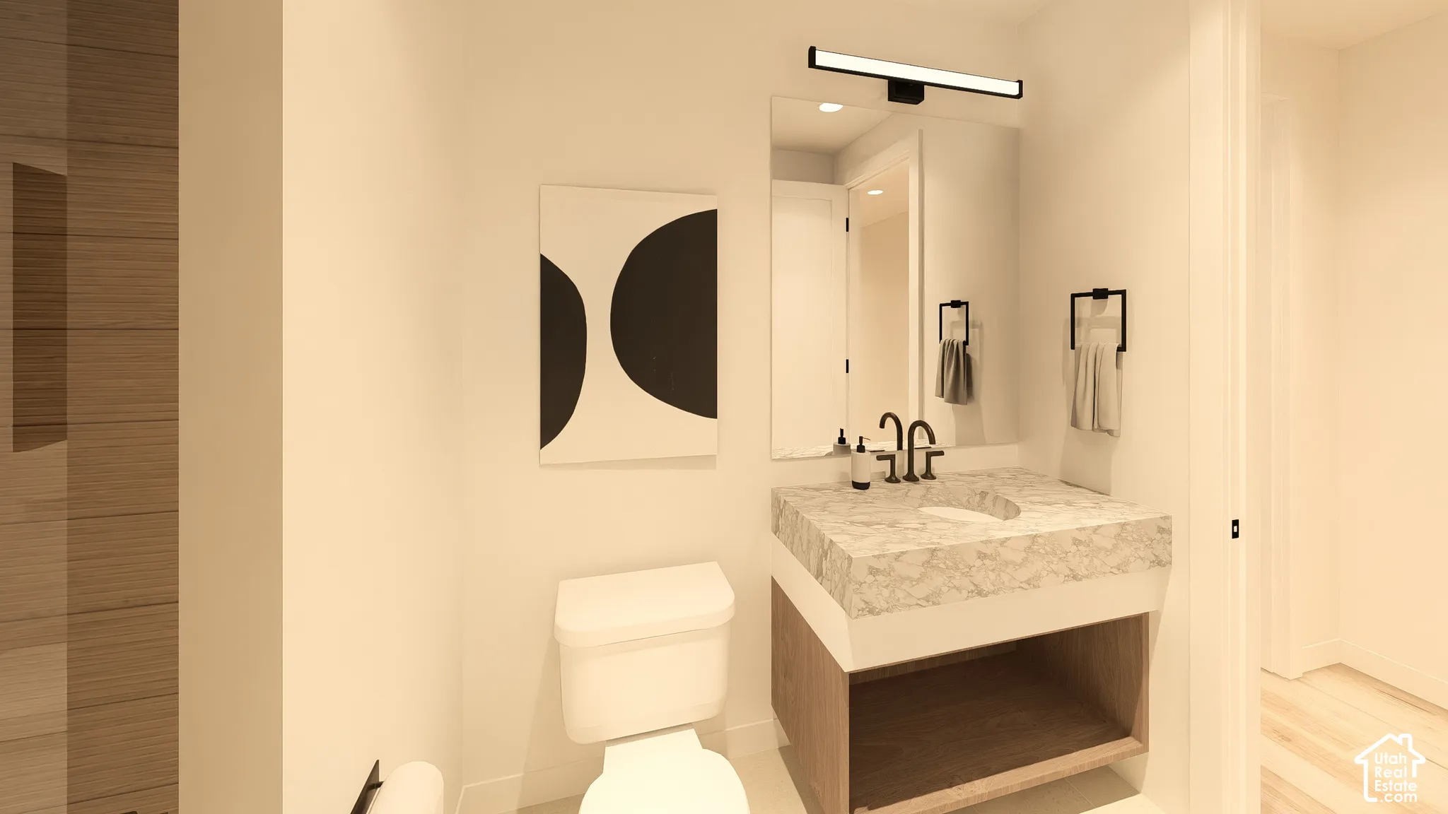 Floating vanity with integrated basin, matte black wall-mounted faucet, and illuminated mirror