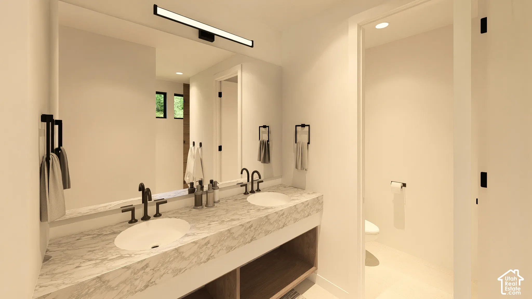 Dual undermount sinks with matte black fixtures, stone-finish countertop, full-width vanity mirror, and built-in vanity lighting