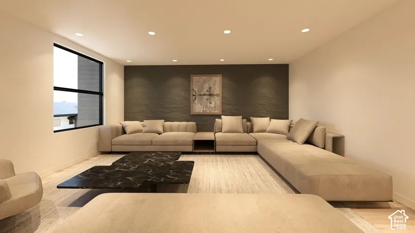 Recessed ceiling lighting illuminates the spacious living area featuring a large window, a dark accent wall, and light-toned flooring