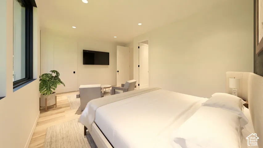 Light wood-finish flooring, recessed lighting, and a mounted flat-screen display