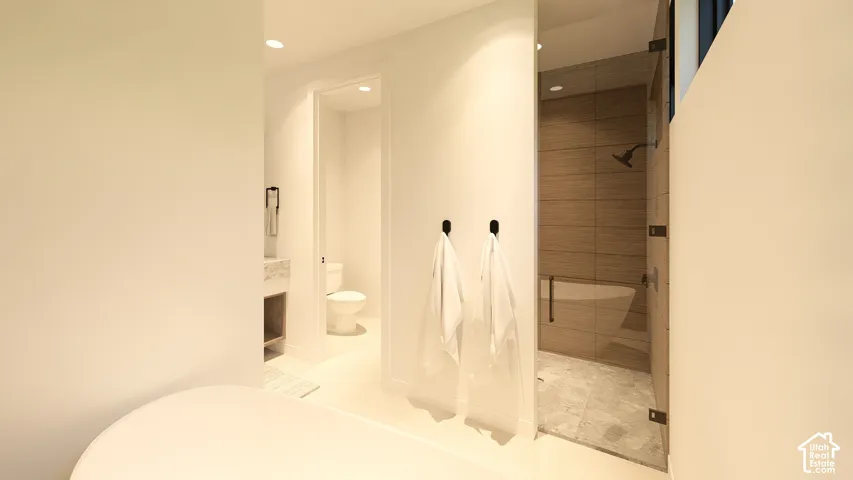 Freestanding soaking tub, glass-enclosed shower with a built-in bench, wall-mounted showerhead, and tile surround