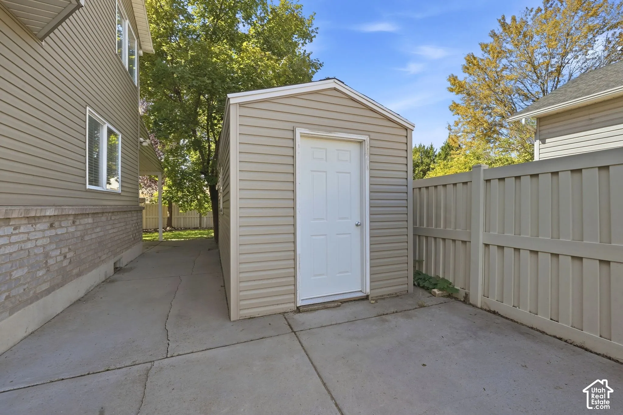 Storage shed with horizontal siding and a single white door