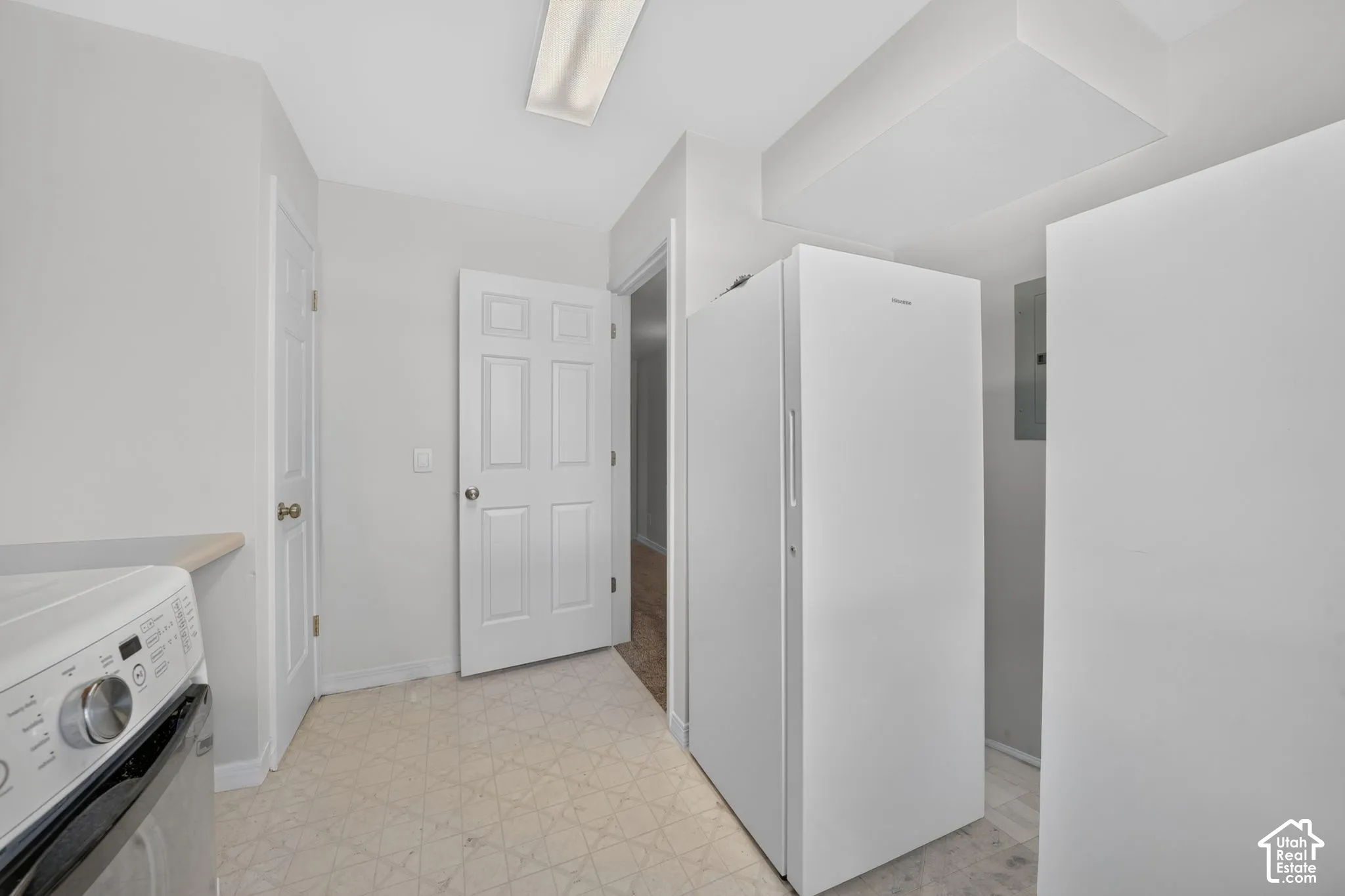 White painted doors, overhead fluorescent lighting, and a neutral-toned floor