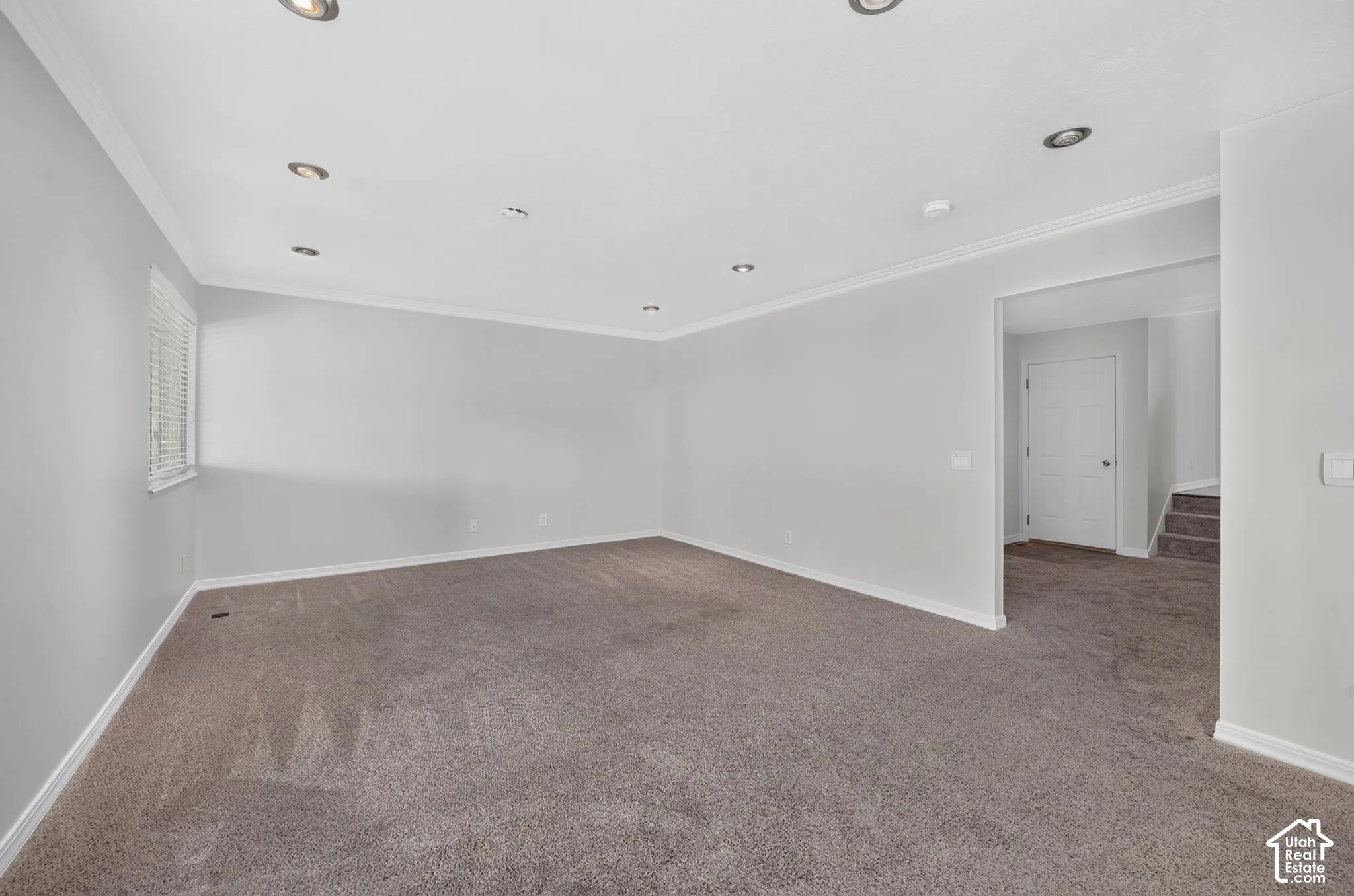 Recessed lighting, crown molding, window with blinds, light gray wall finish, and carpeted flooring