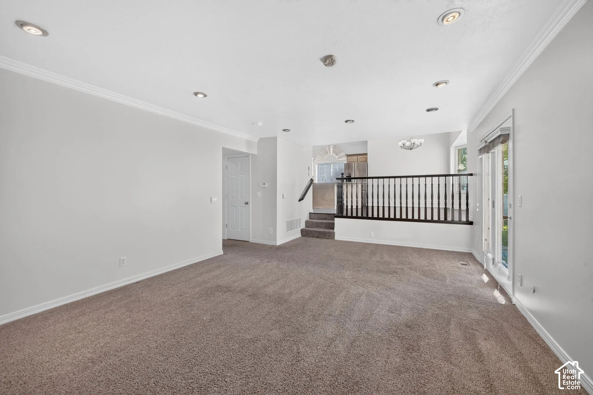 Recessed ceiling lighting, crown molding, and neutral wall tones