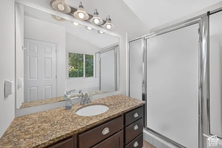 Vanity with a granite countertop, undermount sink, and dark wood cabinetry