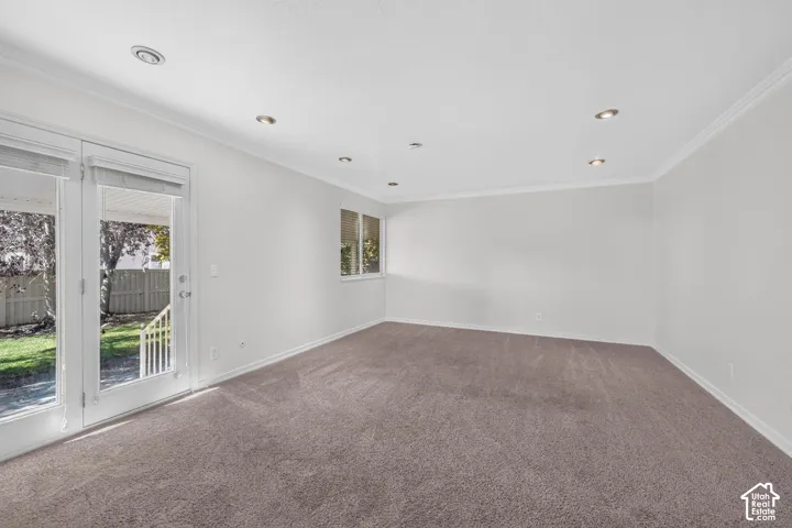 Recessed lighting, crown molding, double French doors, large windows, and carpeted flooring