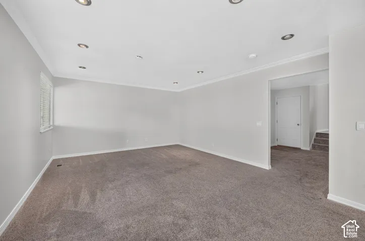 Recessed lighting, crown molding, window with blinds, light gray wall finish, and carpeted flooring