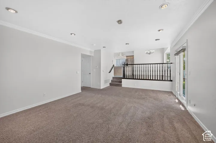 Recessed ceiling lighting, crown molding, and neutral wall tones