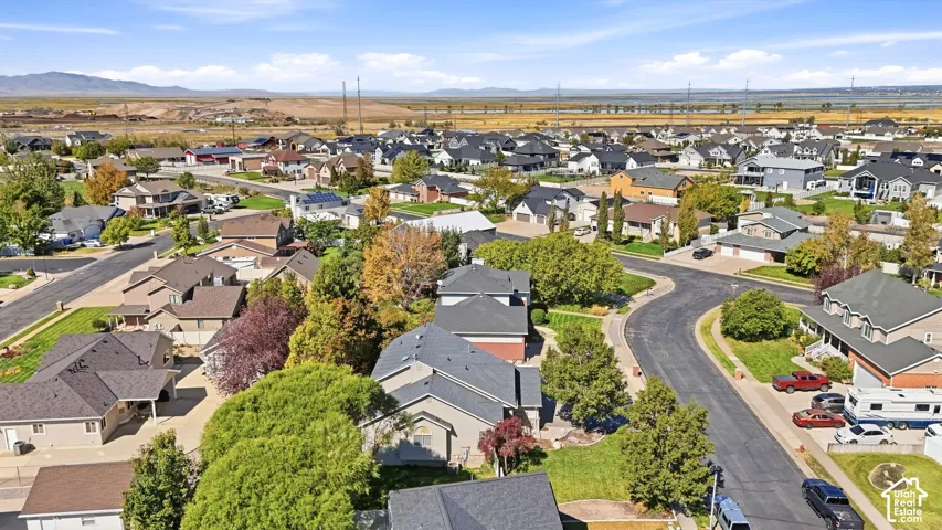 Aerial perspective of a residential community featuring varied home styles, mature landscaping, and paved streets