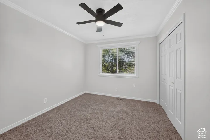 Recessed window with blinds, ceiling fan with integrated lighting, bi-fold closet doors, crown molding, and neutral wall paint