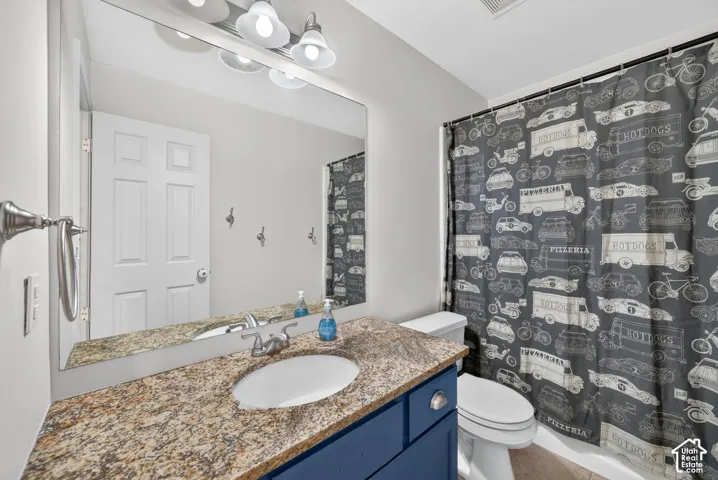 Vanity with a granite countertop, undermount sink, and blue cabinetry