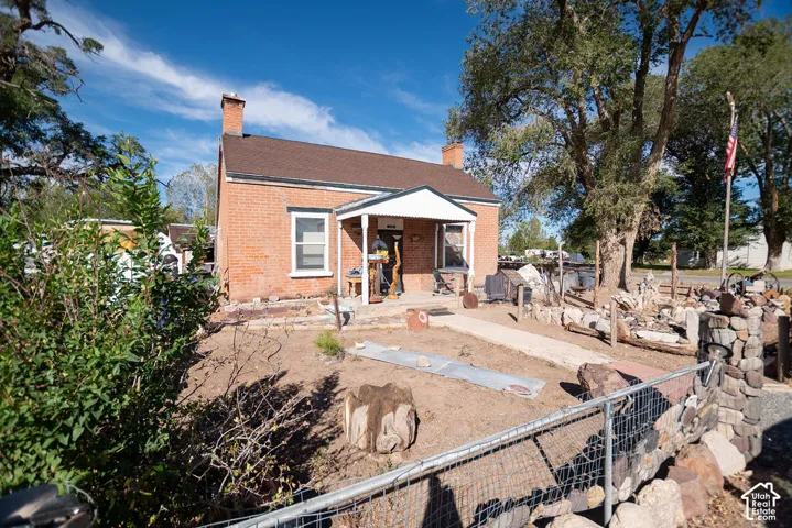 Brick exterior with a shingle roof and front porch