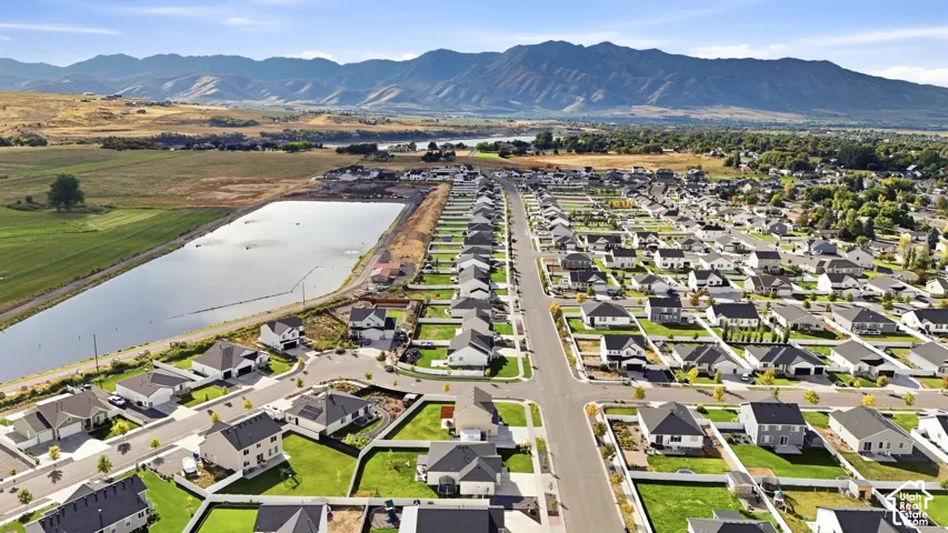 Planned community with a water feature, paved roads, and mountain scenery