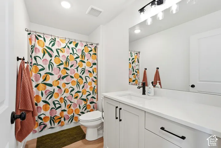 White shaker vanity with matte black hardware, white countertop, rectangular undermount sink, matte black faucet, and frameless mirror