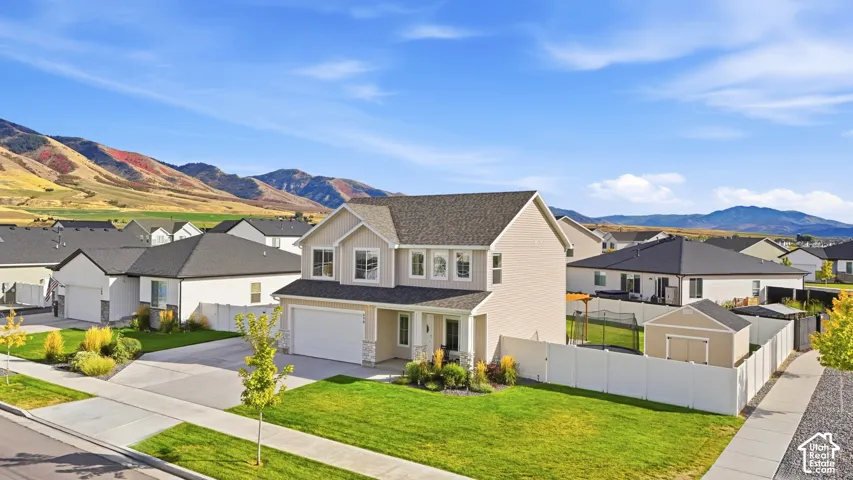 Two-story residence with light-colored siding, a dark roof, and a two-car garage