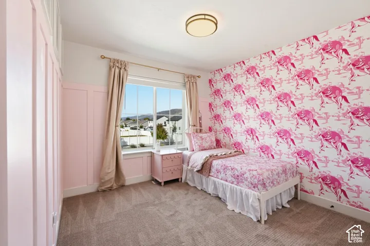 Wall-mounted lighting fixture, picture window, board and batten wall detailing, patterned accent wall, and neutral carpet