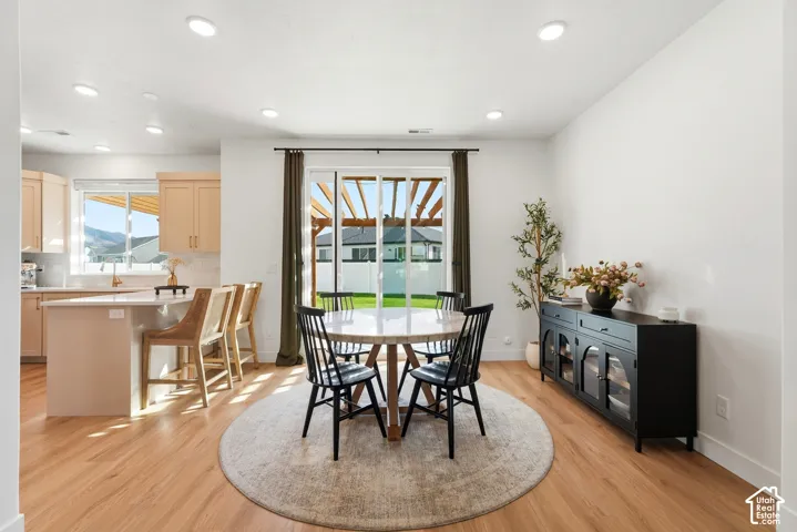 Wood-finish flooring throughout, recessed lighting, and a sliding glass door to the exterior
