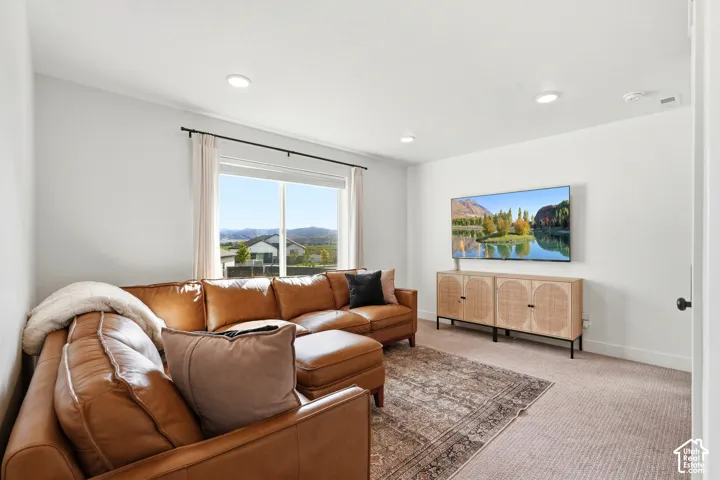 Recessed lighting, wall-mounted television, and a window with mountain scenery
