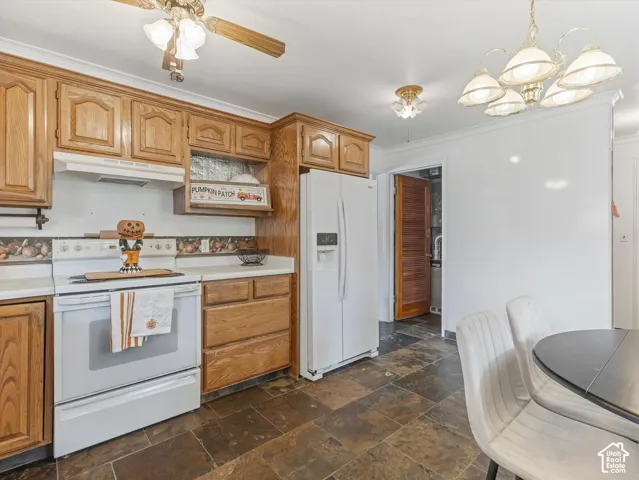 Kitchen with wood cabinetry, white appliances, and slate-finish flooring