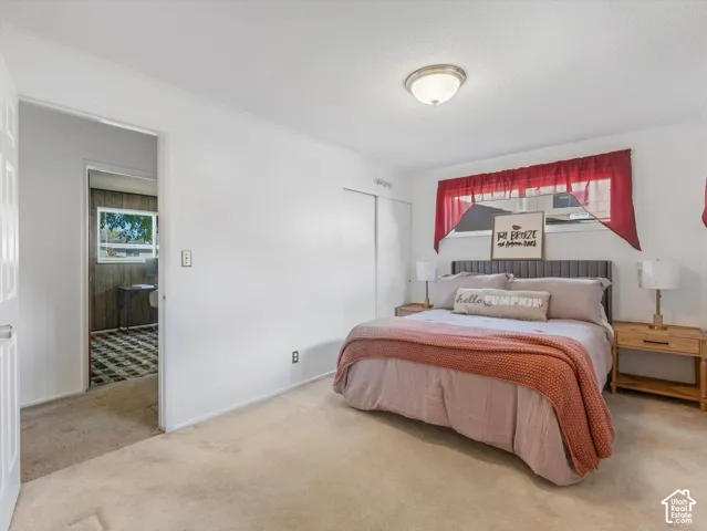 Wall-to-wall carpeting, overhead ceiling light fixture, and closet with sliding doors