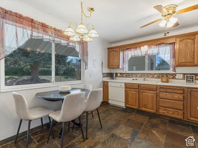 Kitchen featuring wood cabinetry, white countertops, a built-in dishwasher, and slate-finish floor tiles