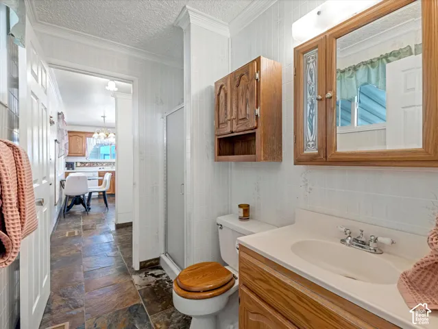 Bathroom featuring a built-in vanity with integrated sink, wood-finish cabinet storage, and a shower enclosure
