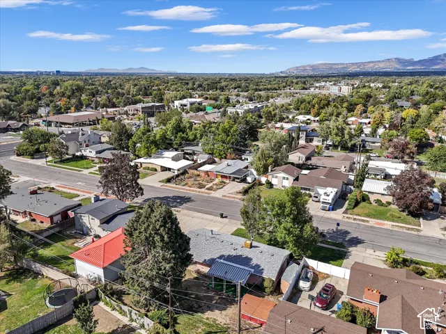 Densely treed neighborhood with varied architectural styles and mountain scenery