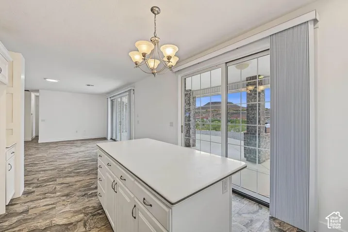 Kitchen island with white countertop, recessed lighting, and elegant chandelier