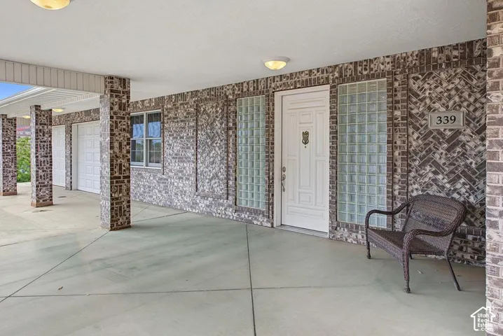 Covered entry with patterned brick facade, glass block sidelights, and a paneled entry door