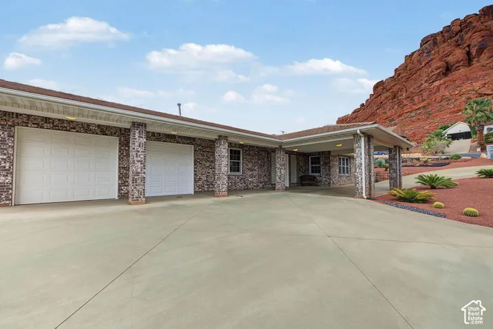 Brick exterior with a covered entryway, attached two-car garage, and a concrete driveway