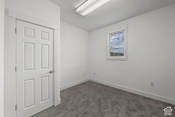 Neutral wall tones, gray carpeting, and a multi-pane window