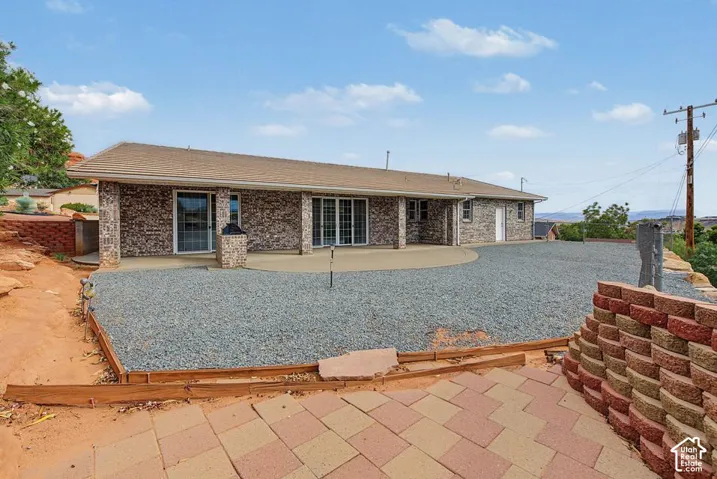 Brick exterior with a shingle roof and multiple sliding glass doors