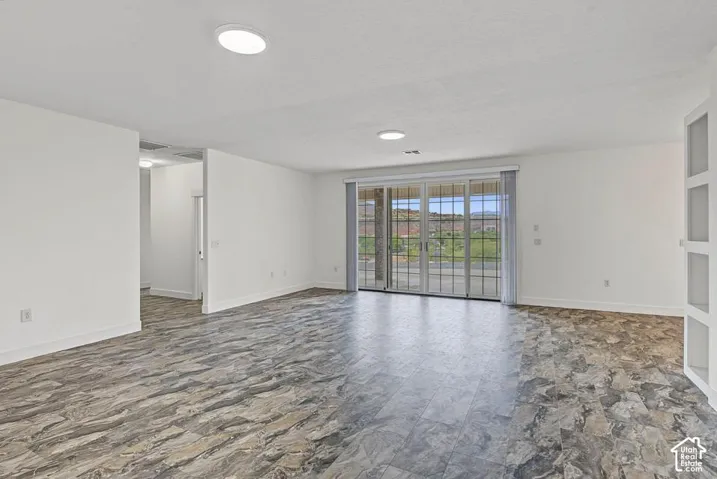 Spacious interior with neutral walls, recessed lighting, patterned tile flooring, and sliding glass doors