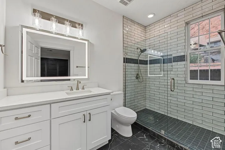White shaker-style vanity with a light-colored countertop and undermount sink
