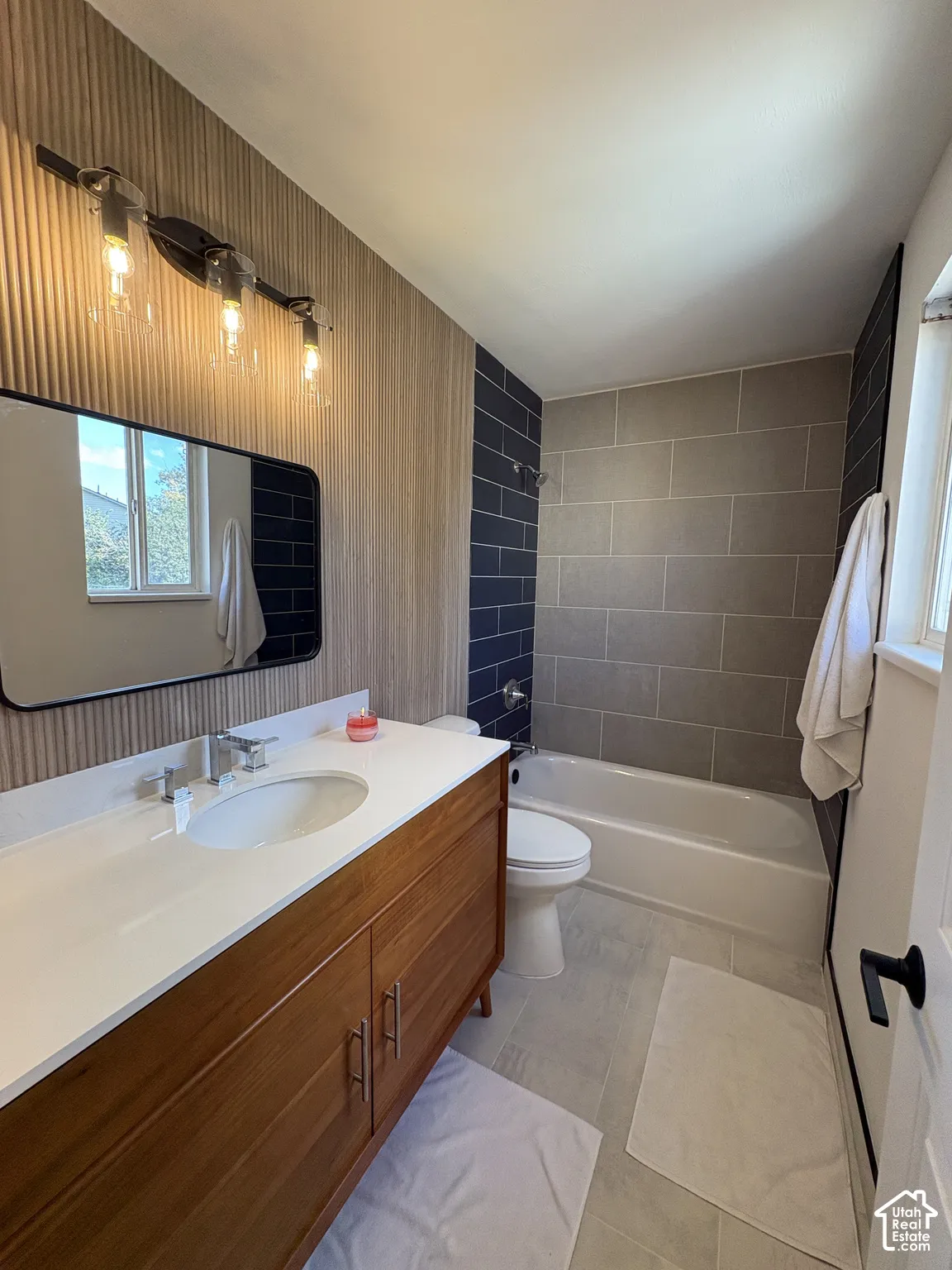 Primary bathroom. Wood-finish vanity with white countertop and integrated sink