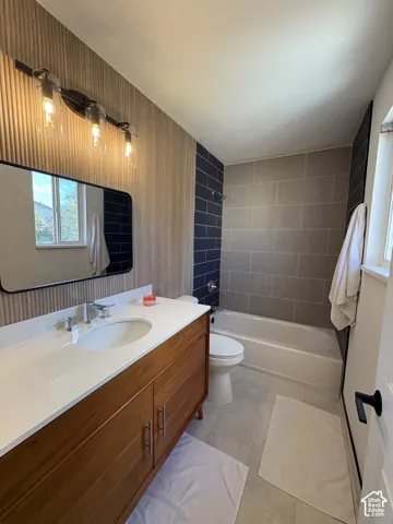 Primary bathroom. Wood-finish vanity with white countertop and integrated sink