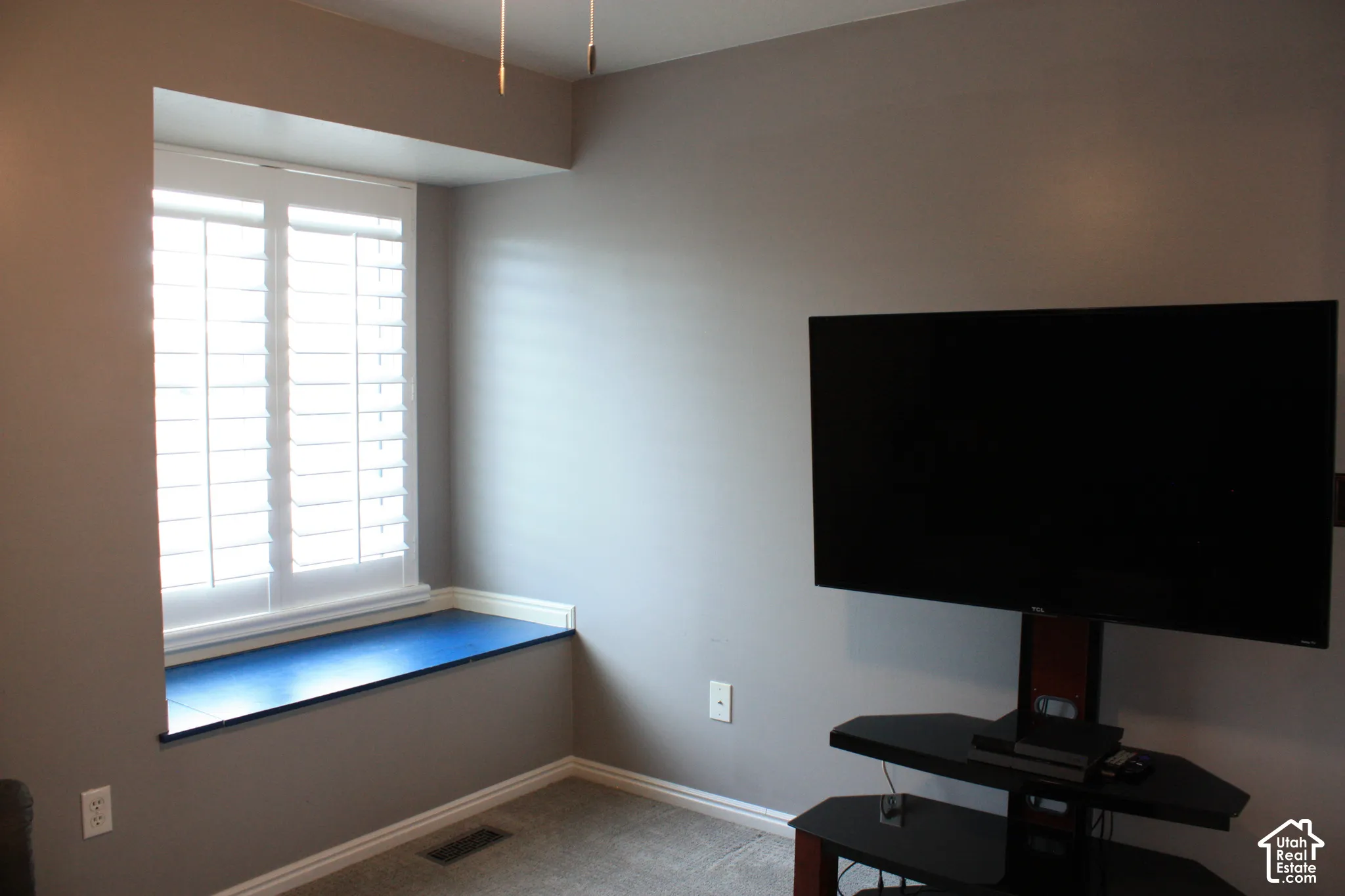 Window with white plantation shutters and an integrated window seat