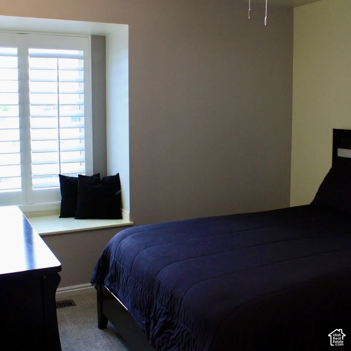 Window with white plantation shutters and a built-in window seat