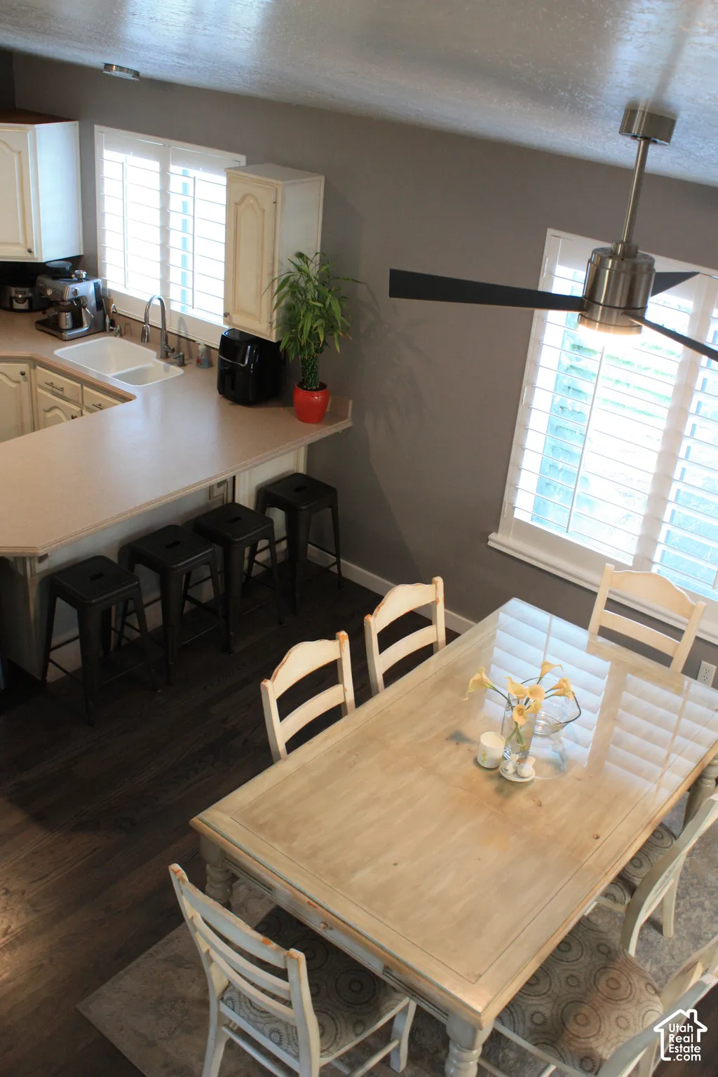 Kitchen featuring a dual-basin sink, light-toned cabinetry, and a breakfast bar