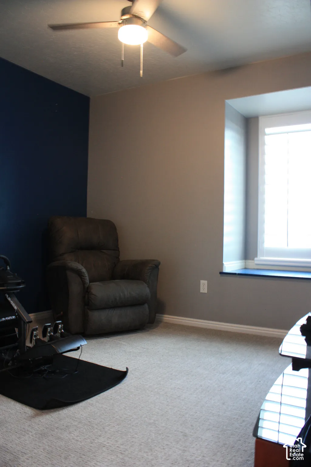 Recessed window with white trim, light gray wall paint, contrasting accent wall, ceiling fan with integrated lighting, and carpeted flooring